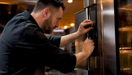 Chef adjusting commercial oven controls