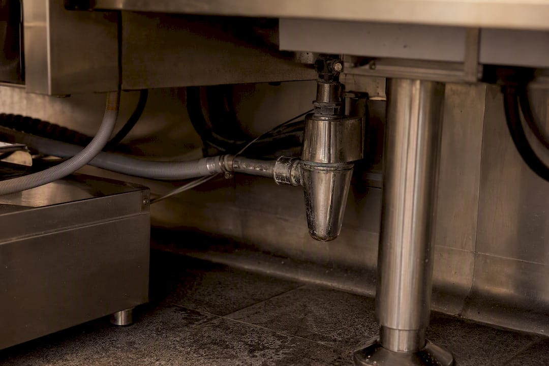 Close-up of combi oven drain siphon and pipes