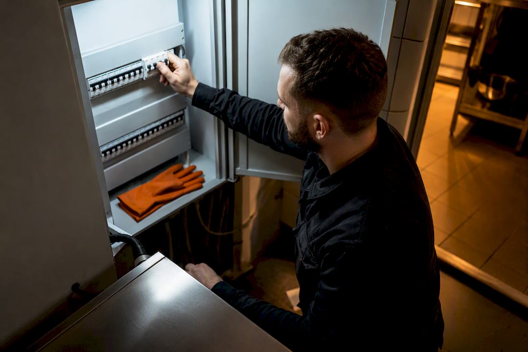 Electrician checking oven circuit breaker