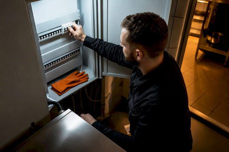 Electrician checking oven circuit breaker