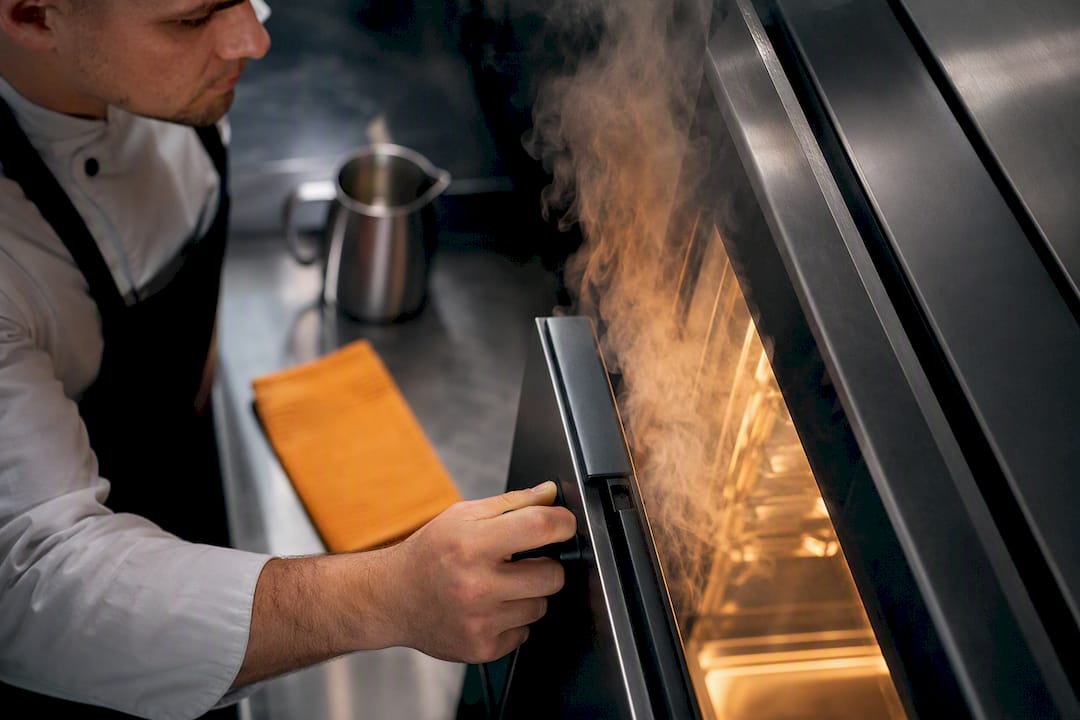 Chef adjusting anonymous combi oven settings